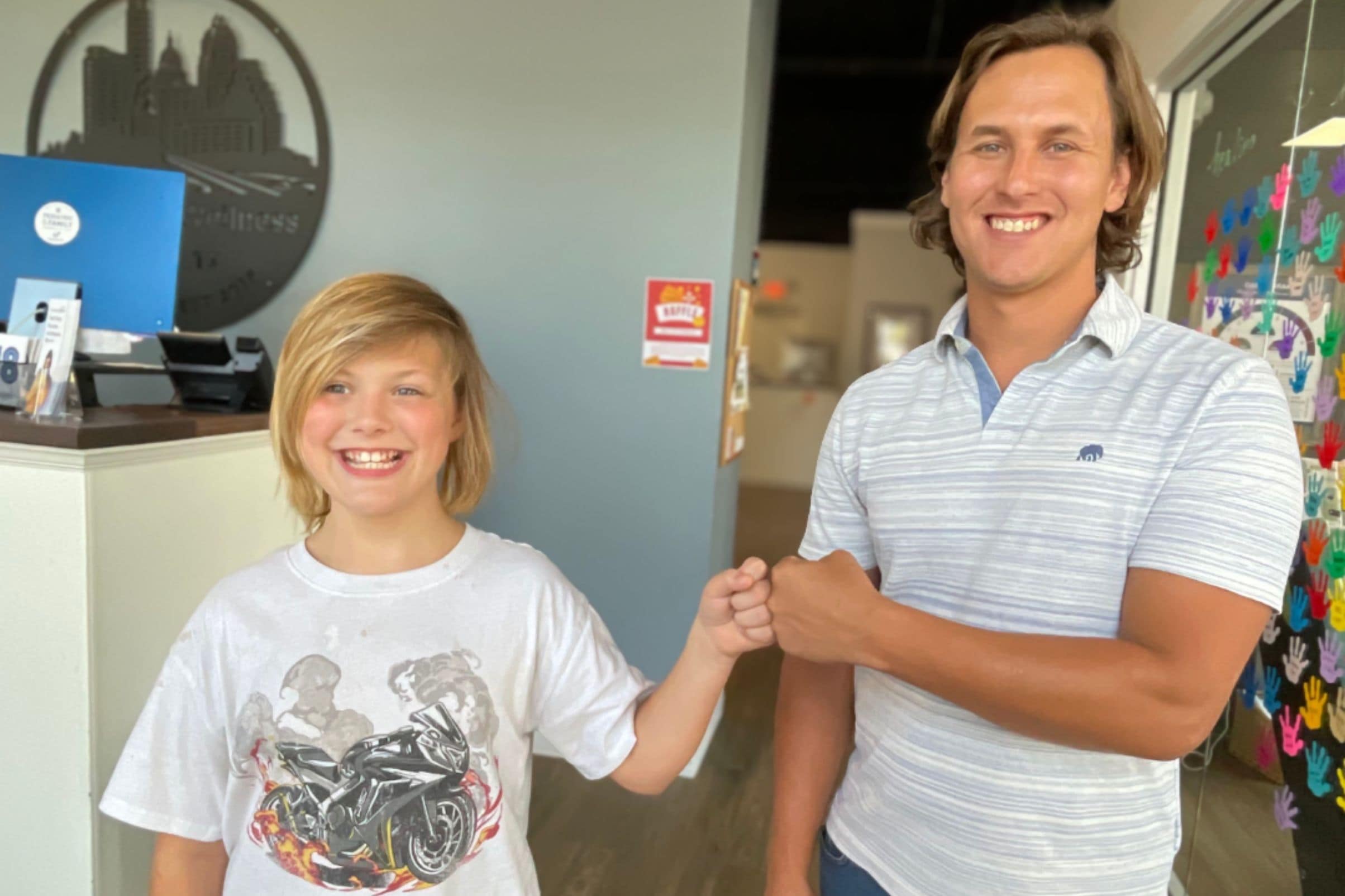 Jayden smiling with a chiropractor in a pediatric chiropractic office